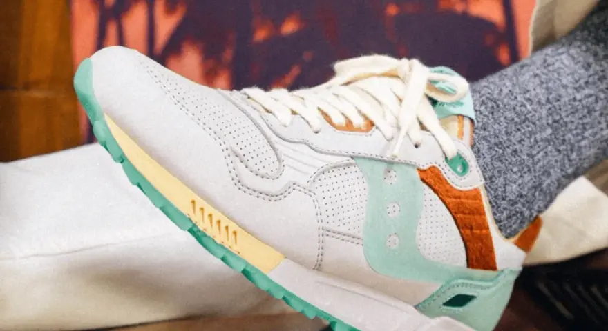 Zapatillas Saucony con detalles en menta y naranja. Consulta la **guía de tallas Saucony** para encontrar tu ajuste perfecto.