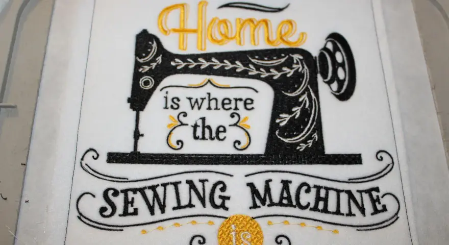 Tipografía para bordar: "Home is where the SEWING MACHINE is". Máquina de coser vintage bordada en negro y dorado.