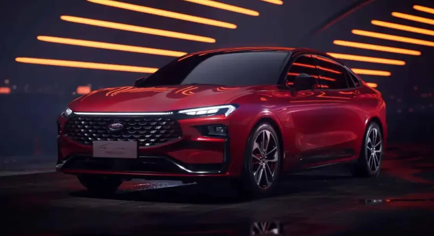Czerwony Ford Mondeo MK6 z nowoczesnym designem, błyszczącym grillem i ostrymi światłami LED, prezentowany na tle pomarańczowych świateł.