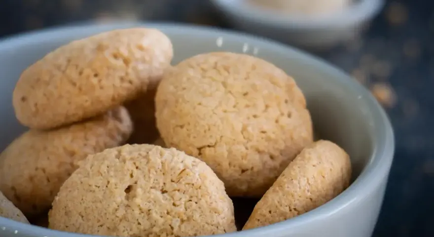 Kleine, goldbraune Amarettini in einer Schale. Dieses Amarettini Rezept ist einfach und gelingt immer.