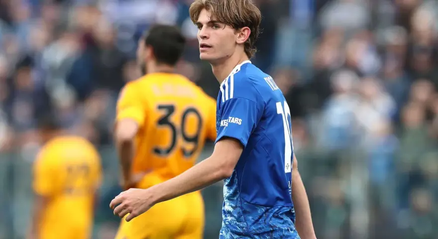 Joven futbolista Nico Paz, con el dorsal 10 en su camiseta azul, mira atentamente el partido.