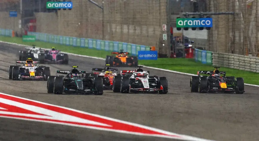 Coches de F1 compiten en una carrera nocturna, anticipando el f1 calendario 2026.