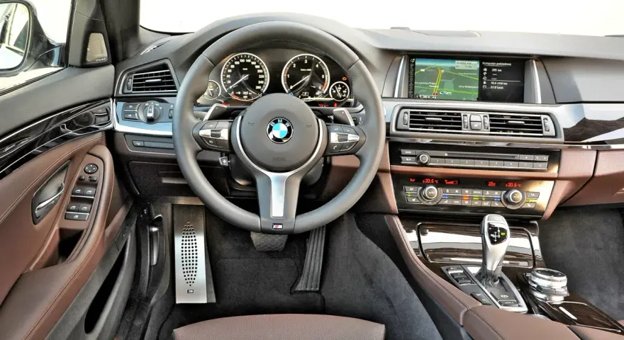 Wnętrze BMW 5 GT: skórzana tapicerka, nowoczesny kokpit z nawigacją i panelem klimatyzacji. Wady i zalety tego modelu warto rozważyć.