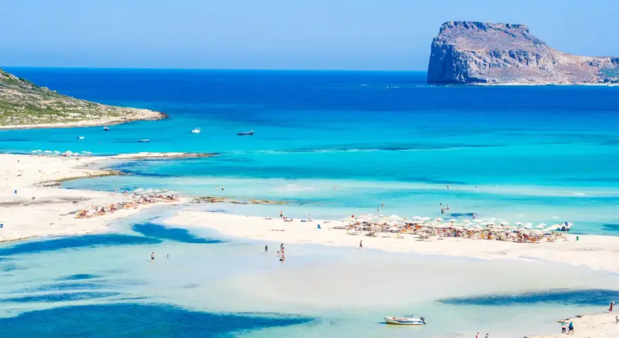 Piękna plaża z turkusową wodą i skalistą wysepką. Czy to Rodos czy Kreta?