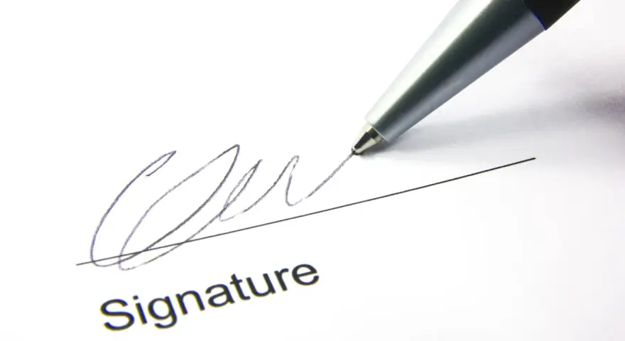 A pen signs a document, finalizing a corporate sponsorship agreement.