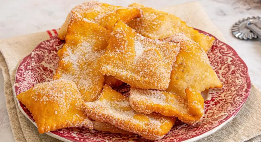 Deliciosas hojuelas fritas espolvoreadas con azúcar, como si fueran miel sobre hojuelas. Un postre crujiente y dulce.