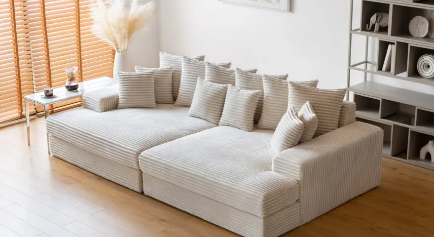 Canapé modulable blanc côtelé, parfait pour un salon cosy. Sa faible hauteur le rend idéal pour un espace moderne.