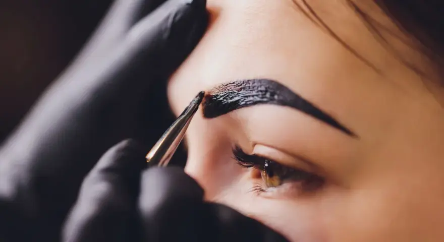Stylist nakłada hennę pudrową na brwi. Zastanawiasz się, ile kosztuje henna pudrowa?