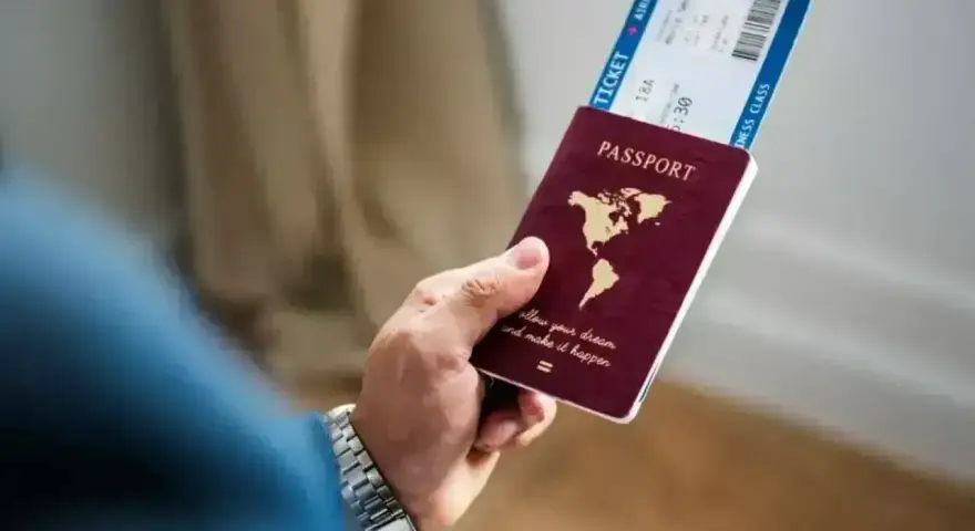 Dłoń trzyma paszport i bilet lotniczy. Planujesz podróż i zastanawiasz się, czy Cypr jest w Schengen?