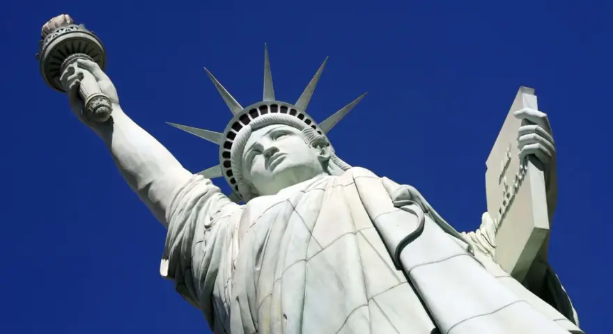 La Statue de la Liberté, une femme emblématique, lève sa torche vers le ciel. Elle porte une tablette, symbole de la loi.