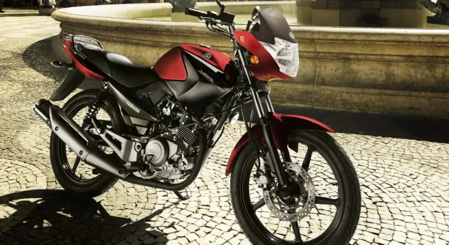 Czerwony motocykl Yamaha YBR 125 na brukowanej ulicy. Sprawdź yamaha ybr 125 dane techniczne, by poznać jego możliwości.
