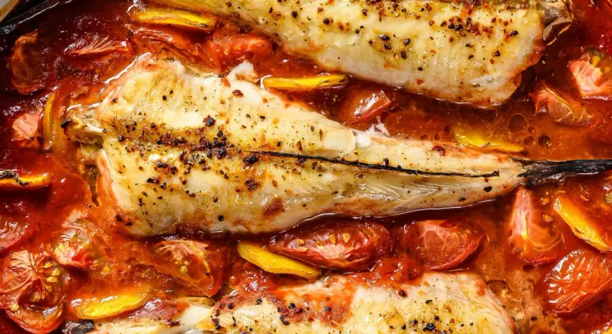 Rape al horno con tomates y limón, un plato jugoso y lleno de sabor.