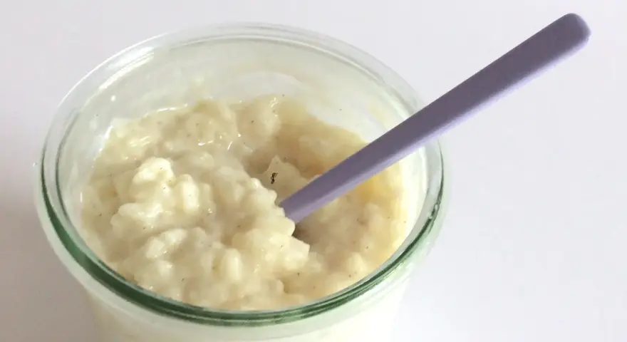 Budino cremoso, profumato alla vaniglia, come quello della ricetta della nonna, pronto per essere gustato con un cucchiaino viola.