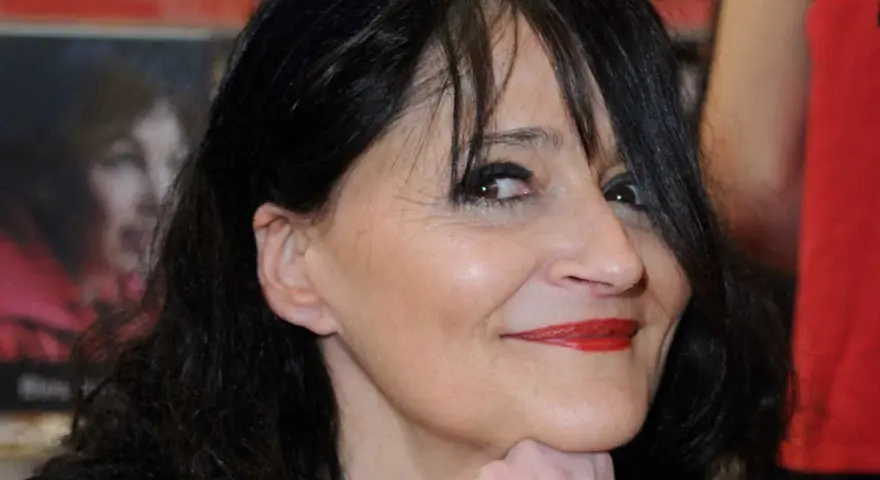 Portrait de Miss.Tic, artiste urbaine dont le décès a marqué le monde de l'art. Son regard pétillant et son sourire énigmatique restent gravés.