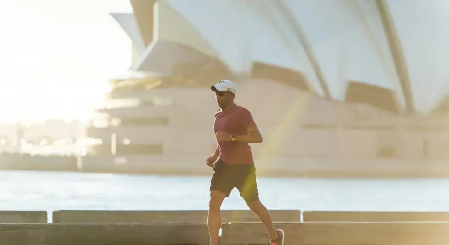 Mężczyzna biegnie przy Operze w Sydney, czerpiąc energię z czystego powietrza. To jego baza tlenowa.