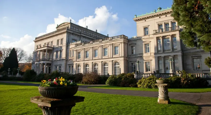Prachtvolle Krupp Villa mit gepflegtem Garten und Blumenkübeln im Sonnenschein.