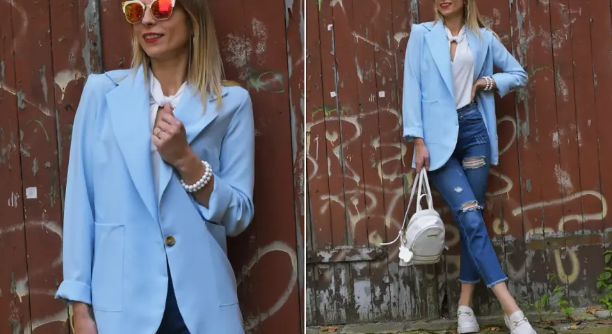 Kobieta w błękitnej marynarce i podartych jeansach prezentuje stylowe stylizacje. Okulary przeciwsłoneczne dodają charakteru.