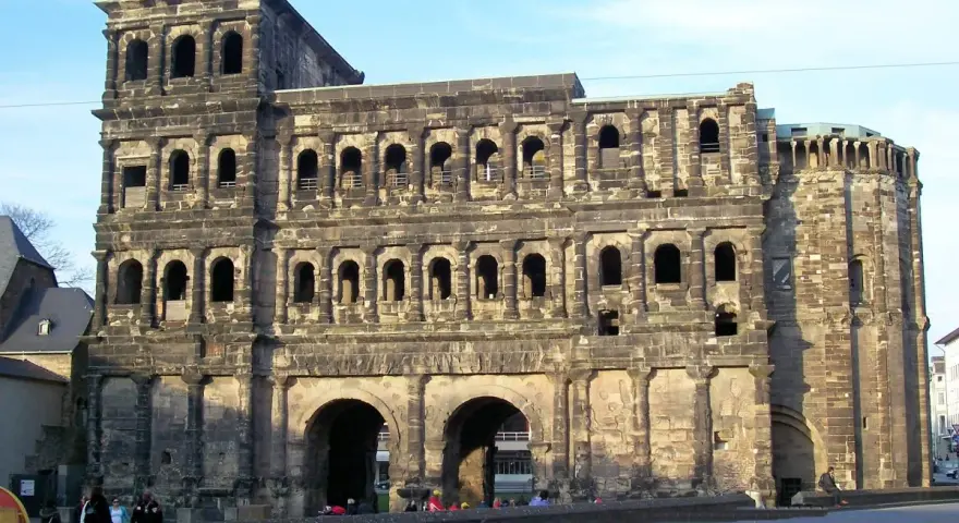 The Porta Nigra, a magnificent example of Trier Roman ruins, stands tall with its imposing stone structure and arched gateways.