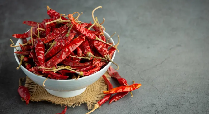 Miseczka pełna suszonych papryczek chili, których ostrość pochodzi od kapsaicyny. Co to jest kapsaicyna? To związek chemiczny odpowiedzialny za pieczenie.