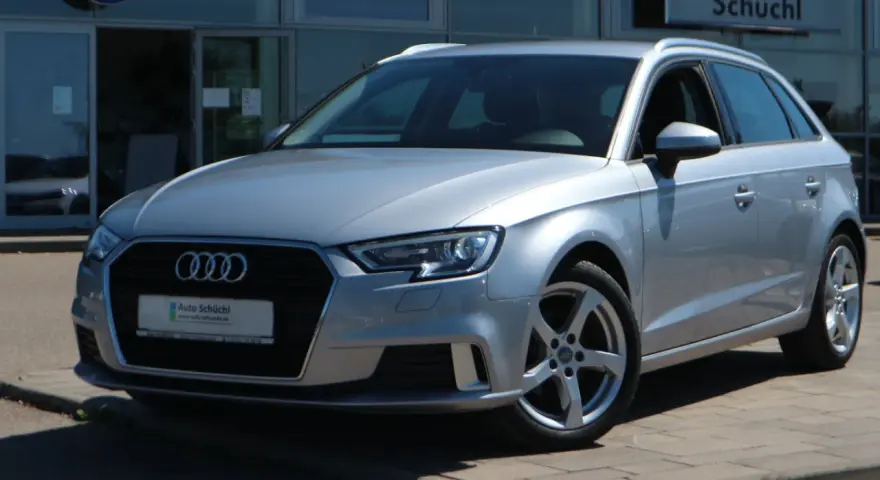 Silberner Audi A3 Avant steht vor einem Autohaus.