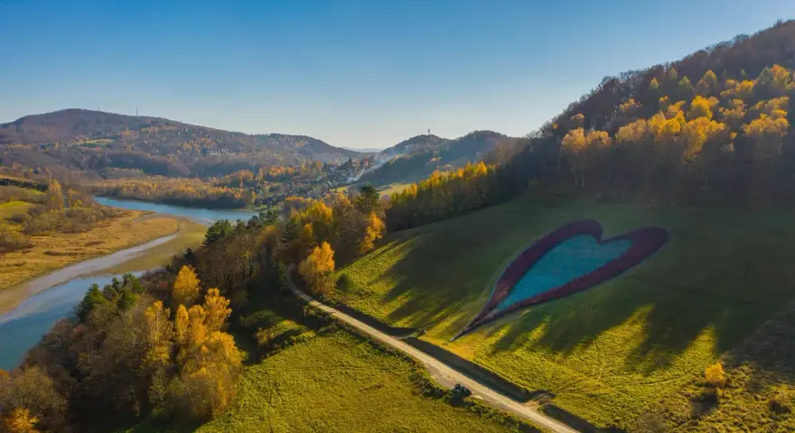 Bieszczady atrakcje: serce na łące, rzeka i jesienne wzgórza.