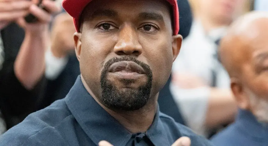 Kanye West w czerwonej czapce i granatowej koszuli, podczas wywiadu.