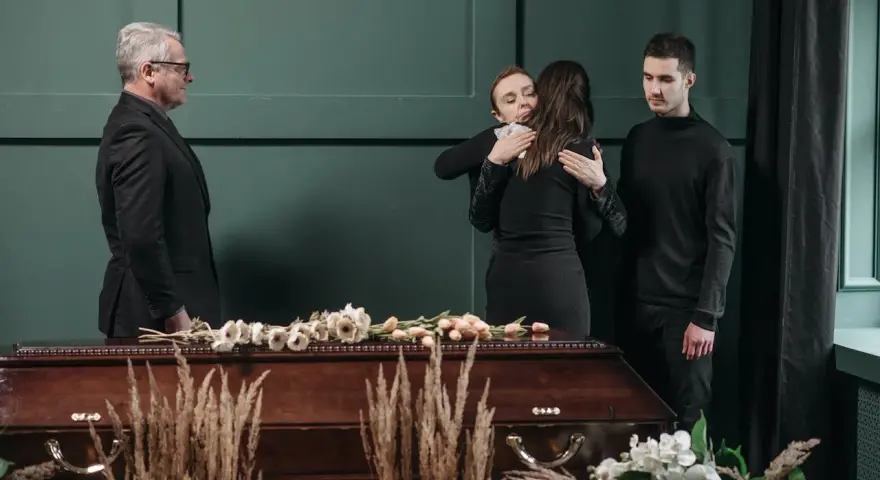 Smutek i żal przy trumnie. Jak się ubrać na pogrzeb znajomego? Elegancki czarny garnitur i sukienka to klasyka.