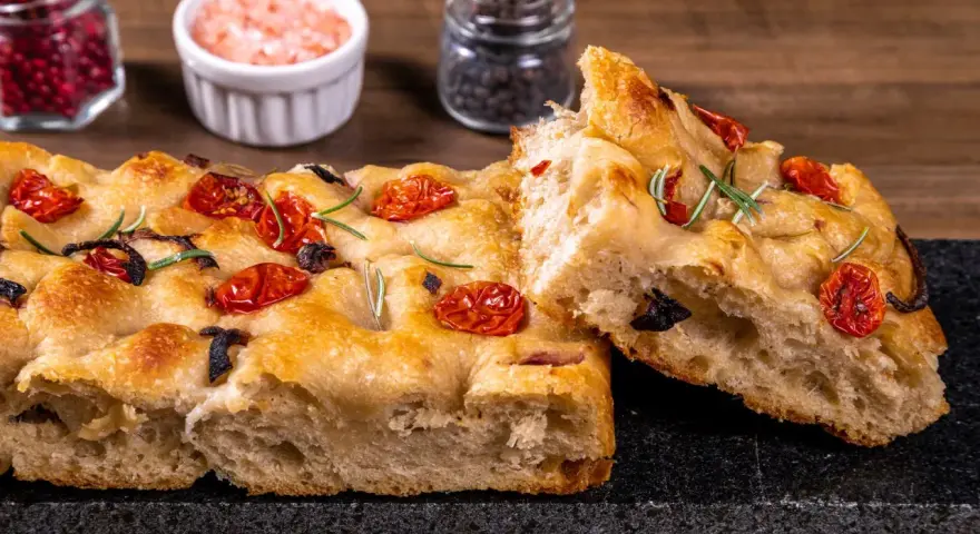 Pyszna, oryginalna włoska focaccia z pomidorkami i rozmarynem. Idealna na przekąskę lub dodatek do dania.