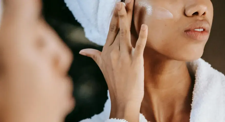 Donna applica crema viso con hydroxypinacolone retinoate, per una pelle luminosa e giovane.