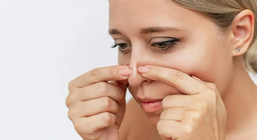 Kvinna undersöker sin näsa, kanske för pormask behandling.