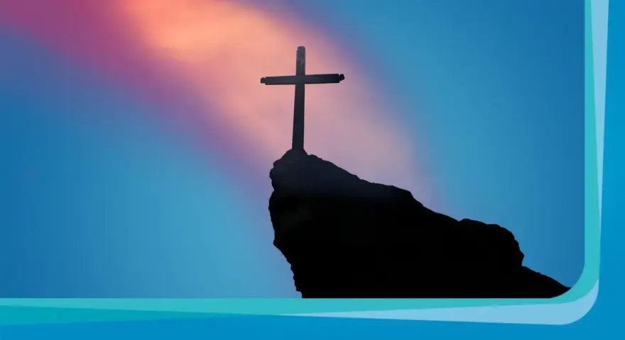 Ein Kreuz ragt auf einem Felsen empor, vor einem farbenprächtigen Himmel. Ein Symbol für Karfreitag und die Hoffnung, die in den Karfreitag Bibelversen liegt.
