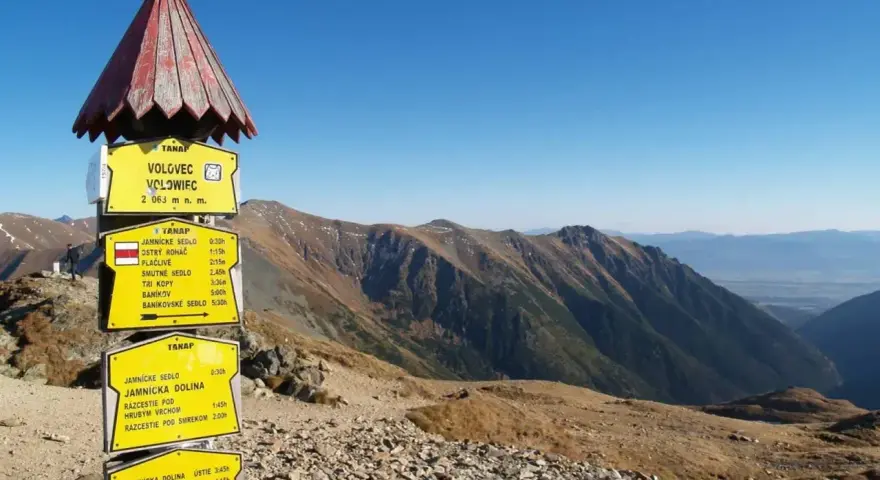 Trasa Grześ-Rakoń-Wołowiec. Tabliczka kierunkowa na szczycie Wołowca (2063 m n.p.m.) wskazuje drogę do Jamnickiego Sedla i innych szczytów.