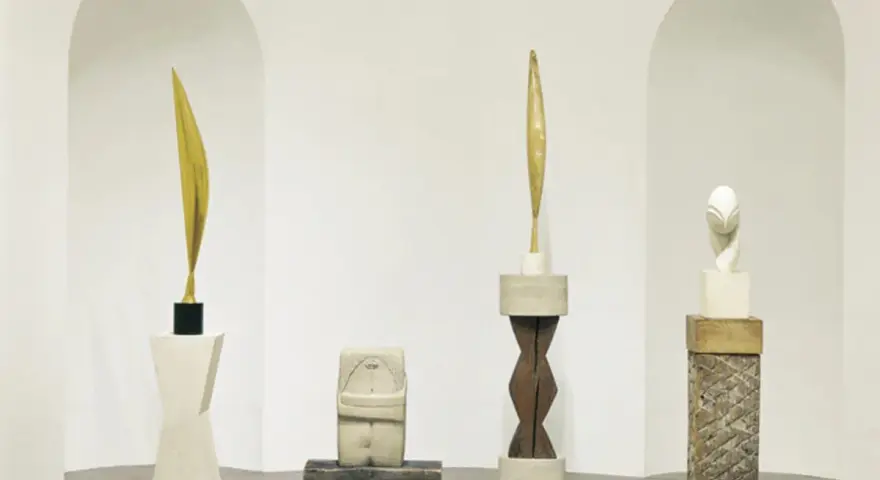 Rzeźby inspirowane twórczością **Constantin Brâncuși**: złoty liść, kamienna postać, drewniany rdzeń i biała głowa.