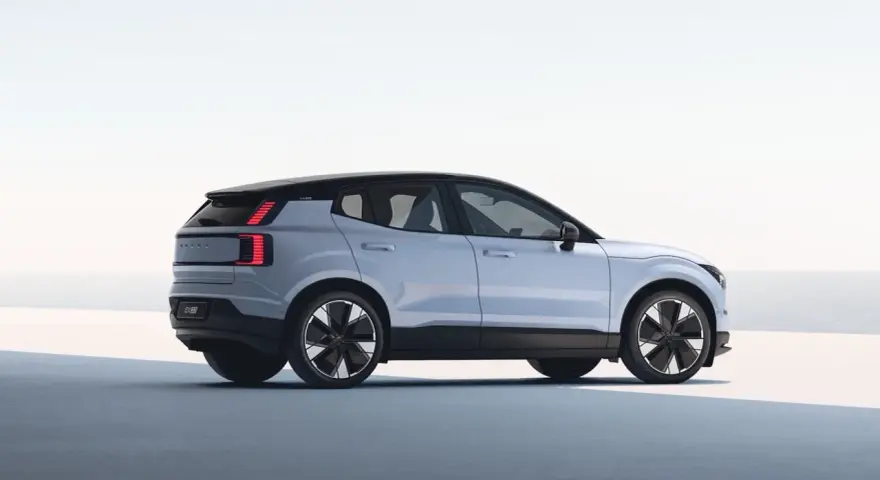 Jasnoszary Volvo EX30 z czarnym dachem i futurystycznymi felgami. Ten elektryczny SUV oferuje imponujący zasięg, idealny na długie podróże.