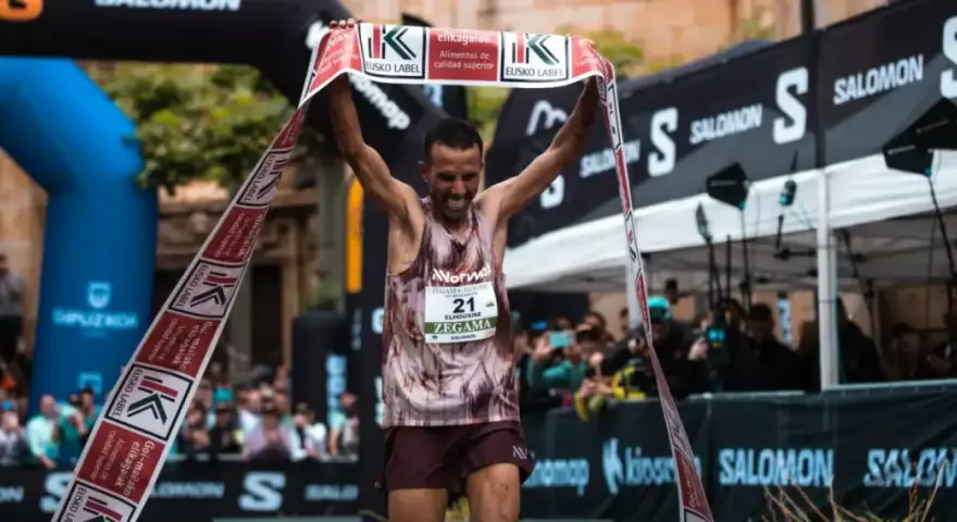 Corredor celebra su victoria en la **Zegama-Aizkorri** rompiendo una cinta.