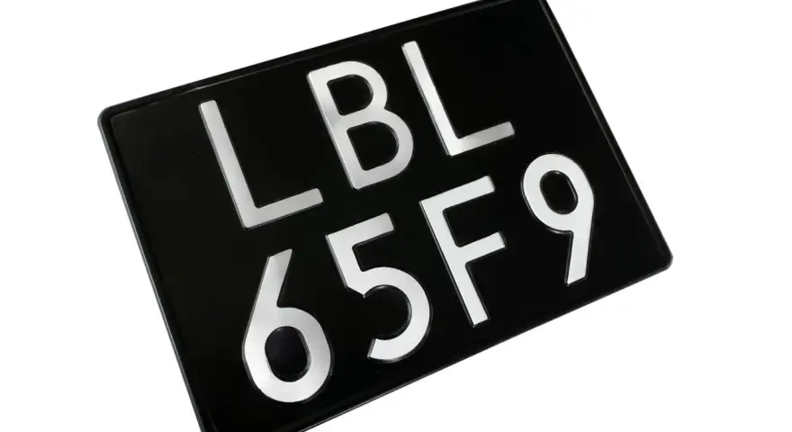 Czarna tablica rejestracyjna LBL 65F9, gotowa do montażu na pojeździe.