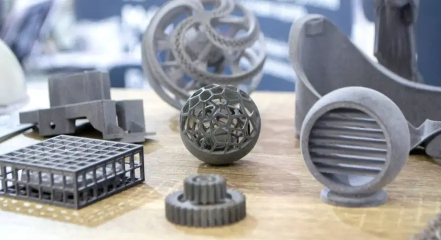 A collection of intricate 3D printing spare parts, including a lattice sphere, gears, and a vent, showcasing advanced manufacturing capabilities.