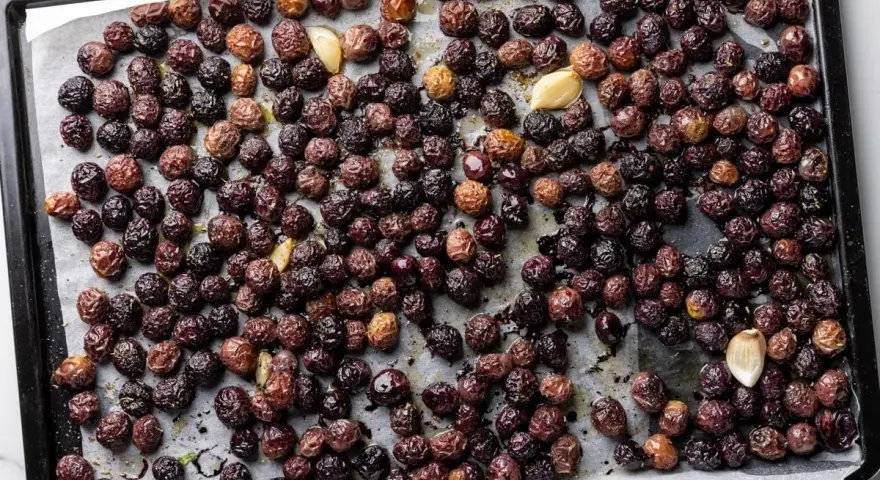 Olive nere al forno alla pugliese, dorate e profumate con aglio, pronte per essere gustate.