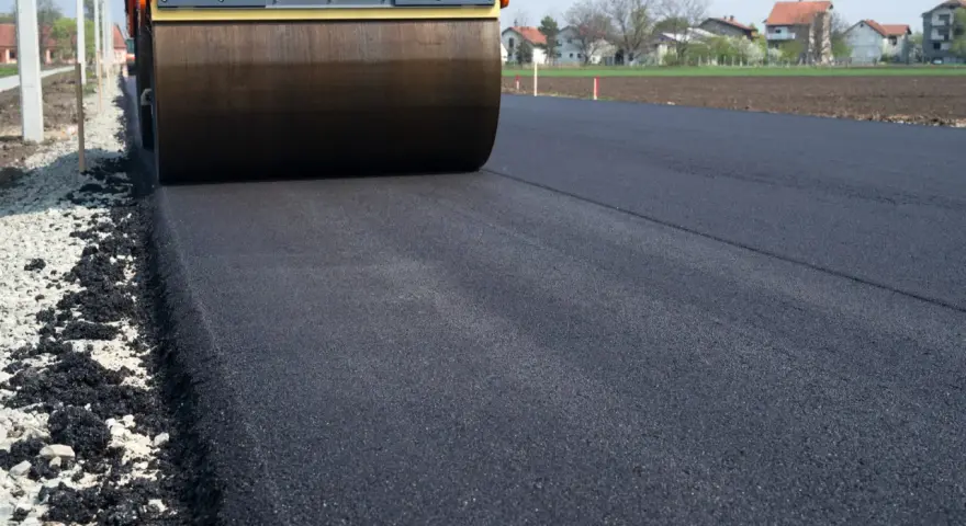 Walec drogowy ugniata świeży asfalt. Zastanawiasz się, ile kosztuje 100 m asfaltu na drodze dojazdowej do domu?