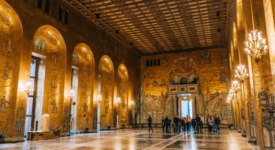 Złote mozaiki zdobią ściany w muzeum w Sztokholmie. Wnętrze olśniewa blaskiem, a grupy turystów podziwiają bogactwo detali.