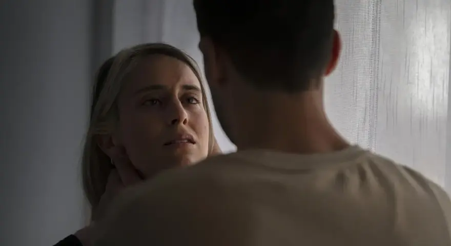 En kvinna med en blick som vittnar om inre styrka möter en mans blick.