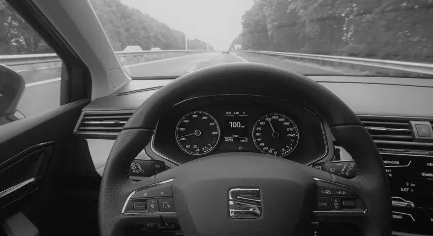 Blick auf das Armaturenbrett eines Autos mit aktiviertem Tempomat. Der Tacho zeigt 100 km/h.