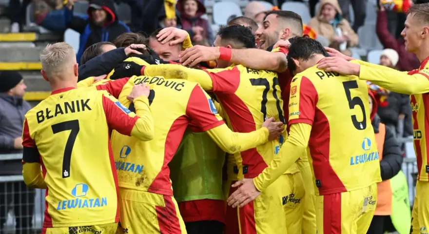 Piłkarze Korony Kielce świętują zwycięstwo nad Górnikiem Zabrze. Radość i okrzyki na boisku, kibice na trybunach.