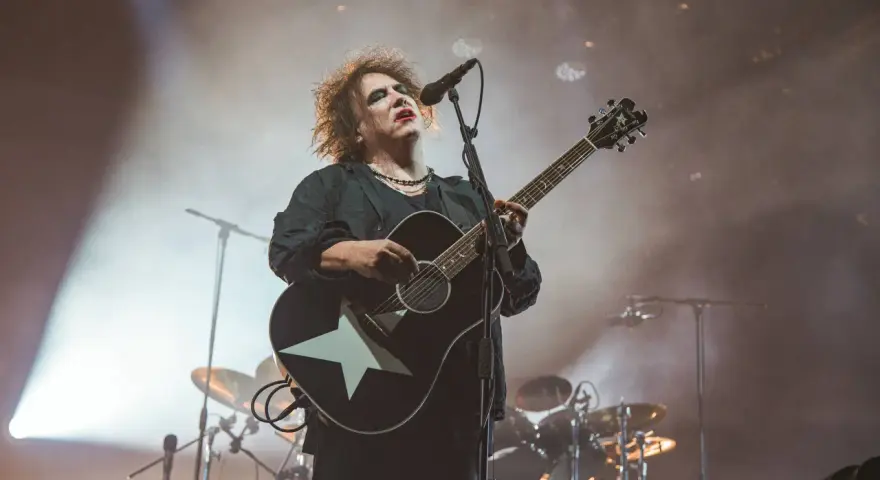 Robert Smith von The Cure spielt auf einer Gitarre mit weißem Stern.