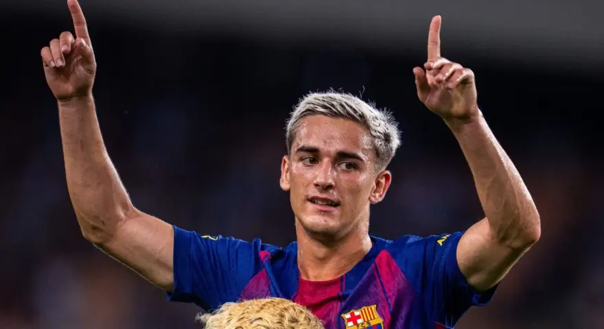 Pablo Gavi, con el pelo teñido de rubio, levanta los brazos y señala al cielo, celebrando un gol.