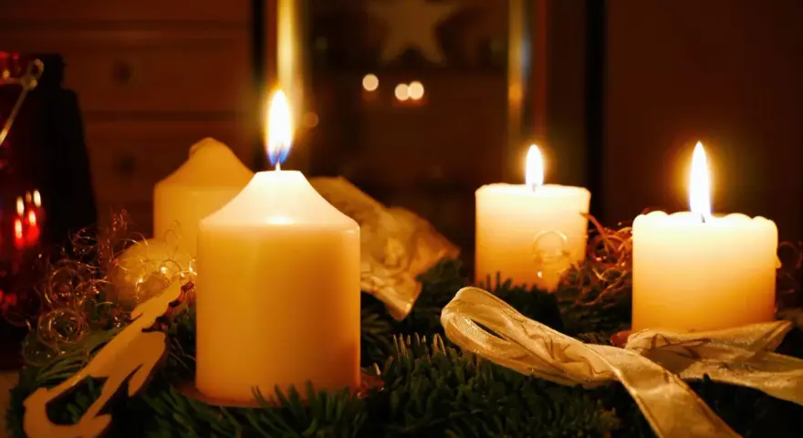 Vier Kerzen auf einem Adventskranz brennen. Der erste Advent ist da und die Vorfreude auf Weihnachten steigt.