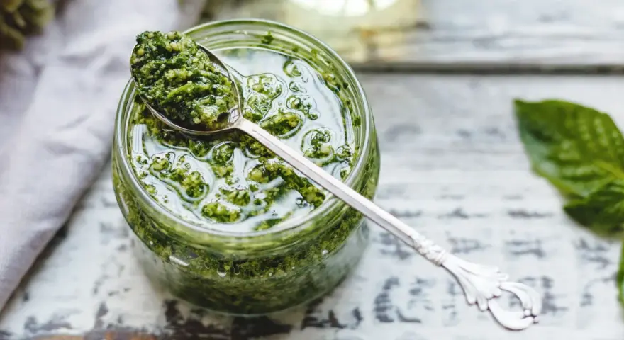 Un cucchiaio di fresco pesto genovese frullatore, pronto per condire la pasta.