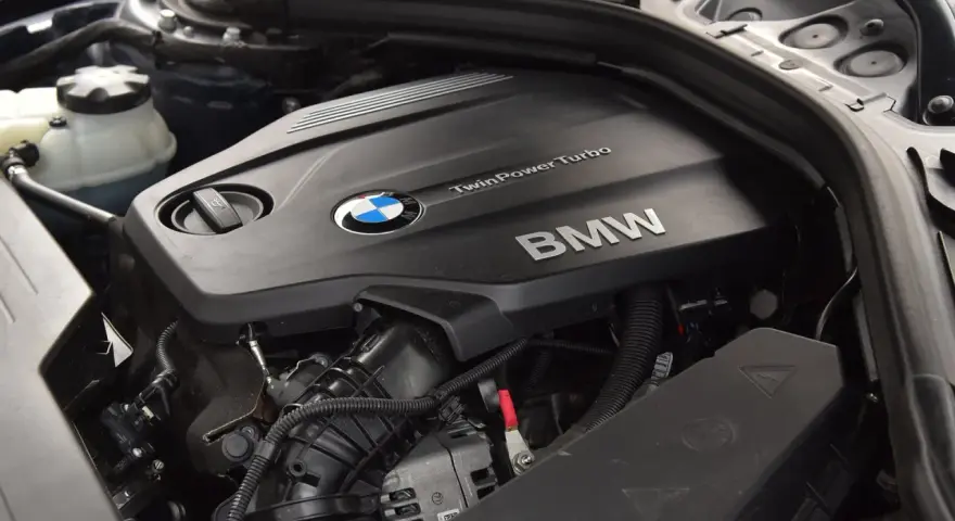 Silnik BMW TwinPower Turbo, prawdopodobnie 2.0 diesel, z widocznym logo BMW i elementami osprzętu.