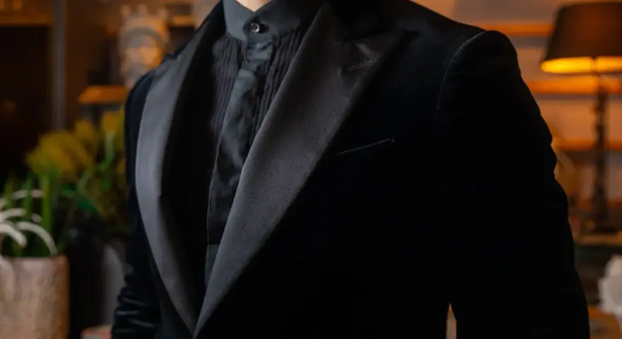 Uomo con abito nero in velluto, camicia con jabot e cravatta. Eleganza senza tempo per un abbinamento perfetto.