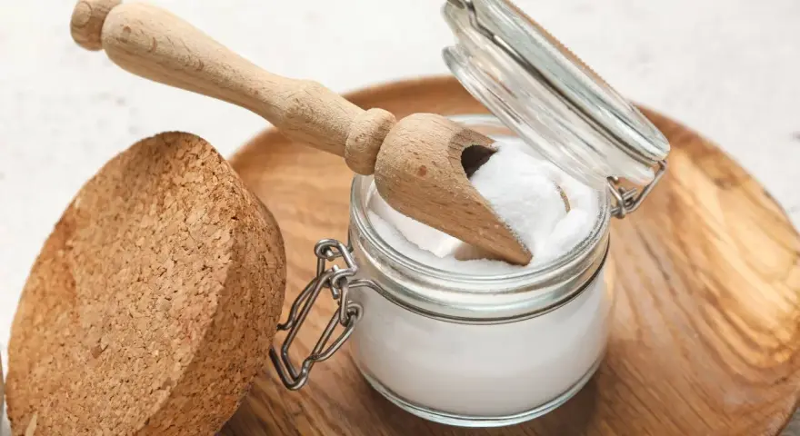 Ein Glas mit weißem Pulver, das nach "was ist Soda" fragt, daneben ein Holzschaufelchen und ein Korken.